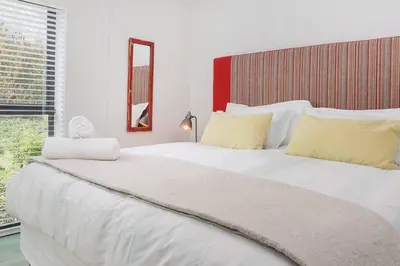a large white bed in a room with a window at Kingklip by Top Destinations Rentals in Hermanus