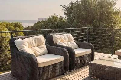 two wicker chairs sitting on top of a deck at Kingklip by Top Destinations Rentals in Hermanus