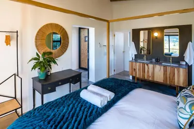 a bedroom with a large bed and a bathroom at Bains View Olive and Guest Farm in Wellington