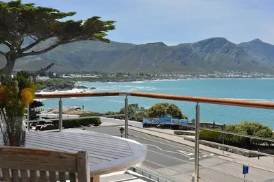 a balcony with a bench and a view of the ocean at Hermanus Seaview Apartment in Hermanus