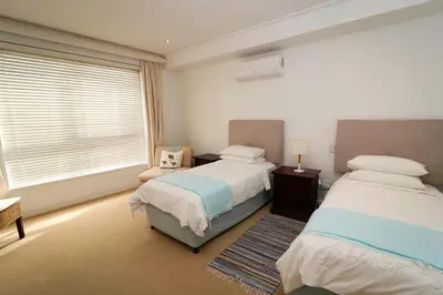 a bedroom with two beds and a window at Hermanus Seaview Apartment in Hermanus