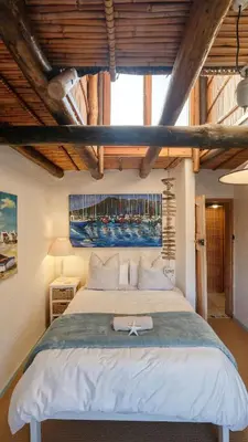 a bedroom with a large white bed in a room at Rox Villa in Rooiels