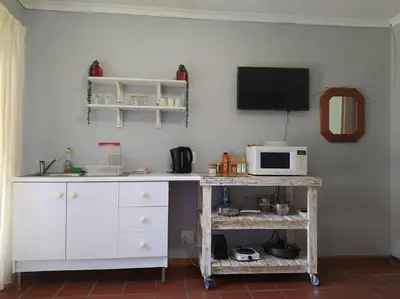 a kitchen with a microwave and a table with a microwave at Garden cottage in Cape Town