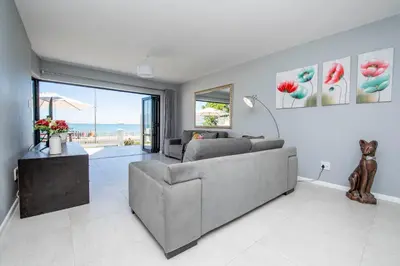 a living room with a couch and a table at Cap du Mont in Bloubergstrand