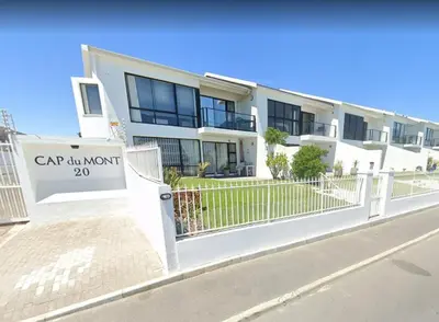 a building with a sign in front of it at Cap du Mont in Bloubergstrand