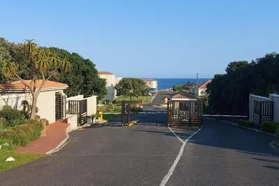 an empty street with a gate in a residential neighbourhood at First Group Hermanus Beach Club in Hermanus
