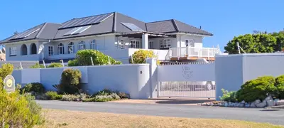a house with a white fence in front of it at Villa Venusta Luxury Guesthouse - Solar Power in Hermanus