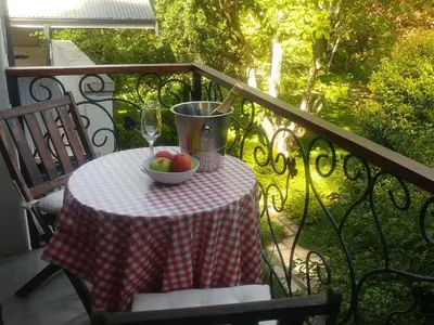 a table with a bowl of fruit and a glass of wine at Aan De Vliet Guest House in Stellenbosch