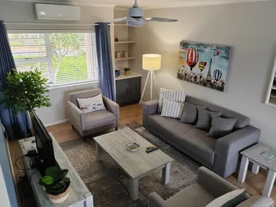 a living room with a couch and a table at Leafy Retreat Kenridge in Durbanville