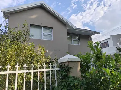 a white fence in front of a house at Leafy Retreat Kenridge in Durbanville