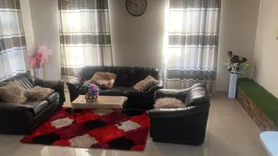 a living room with couches and a coffee table at SABATH LODGE TWO in Cape Town