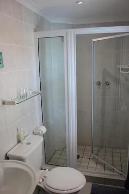 a bathroom with a shower and a toilet and a sink at Old Oak Guest House in Bellville
