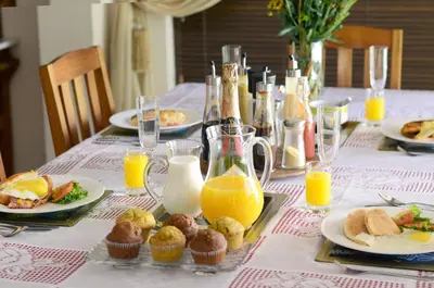 a table topped with plates of food and orange juice at Old Oak Guest House in Bellville