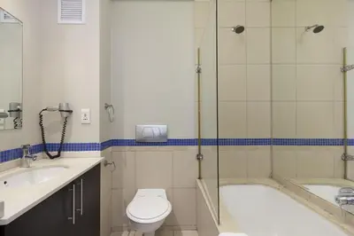 a bathroom with a tub and a toilet and a sink at Lagoon Beach 302A in Cape Town