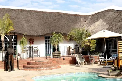 a man standing in front of a house with a pool at House of Perez in Wellington