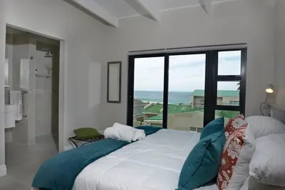 a bedroom with a bed with a view of the ocean at The Whale and Waddler - Unit with a view in Kleinmond
