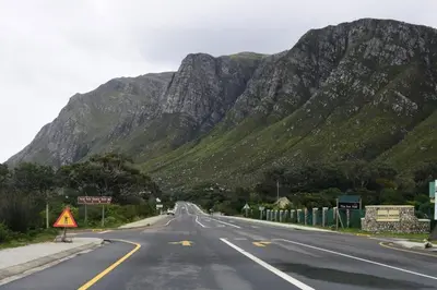 an empty road with a mountain in the background at The Whale and Waddler - Unit with a view in Kleinmond