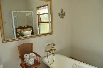 a bath tub in a bathroom with a mirror at Blou Porselein Guestfarm in Hermon