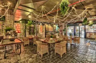a restaurant with tables and chairs and lights at Heritage Square Apartments in Durbanville
