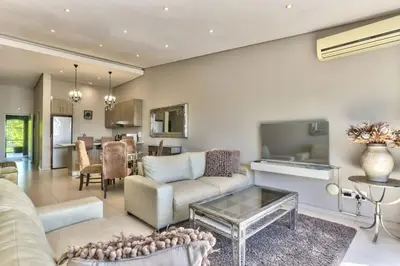 a living room with a couch and a table at Heritage Square Apartments in Durbanville