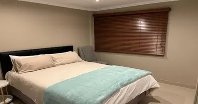 a bedroom with a large bed with a window at 2 Bedroom Oceanfront Apartment with Sea Views in Cape Town