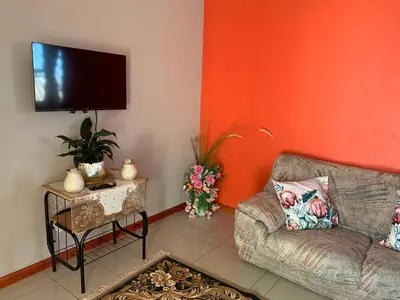 a living room with a couch and a flat screen tv at manu'z in Cape Town