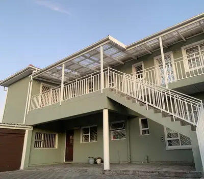 a green house with a balcony on top of it at manu'z in Cape Town