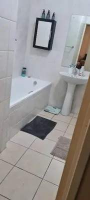 a bathroom with a bath tub and a sink at SEASCAPE MEWS 27 in Cape Town