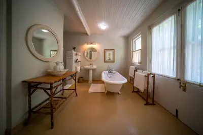 a bathroom with a tub and a sink and a mirror at Bartholomeus Klip Farmhouse at Elandsberg Nature Reserve in Hermon