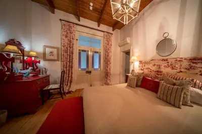 a bedroom with a bed and a desk and a window at Bartholomeus Klip Farmhouse at Elandsberg Nature Reserve in Hermon