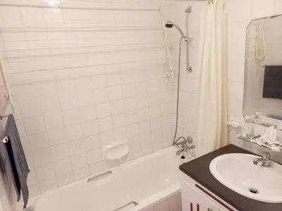 a bathroom with a sink and a tub and a toilet at Cozy Strand Beach Getaway - Studio Apartment in Cape Town