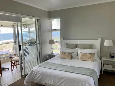 a bedroom with a bed with a view of the ocean at 31 Tobago Bay in Hermanus