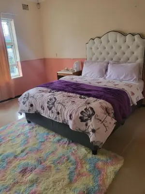a bedroom with a large bed and a rug at Mestil Guesthouse in Cape Town