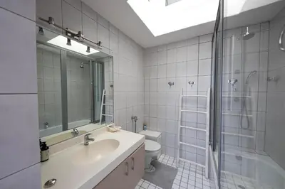 a bathroom with a sink and a shower and a toilet at Beach2Anchor, Beachfront 4 bedroom condo with Jacuzzi in Gordonʼs Bay
