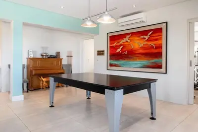 a black ping pong table in a room with a piano at Stamford on Sea by Top Destinations Rentals in Hermanus