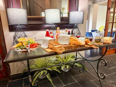 a table with bread and other foods on it at Boord Guest House in Stellenbosch
