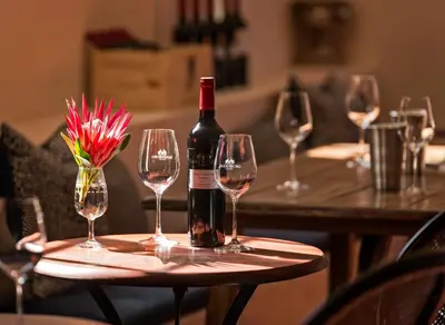 a bottle of wine sitting on a table with wine glasses at Saxenburg Wine Farm in Kuilsrivier