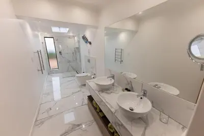 a white bathroom with two sinks and a shower at Saxenburg Wine Farm in Kuilsrivier