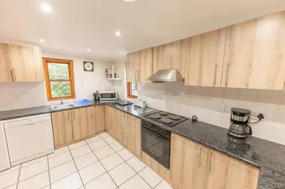 a kitchen with wooden cabinets and a stove top oven at Saxenburg Wine Farm in Kuilsrivier