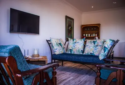 a living room with a blue couch and a tv at 41 on Siffie in Hermanus
