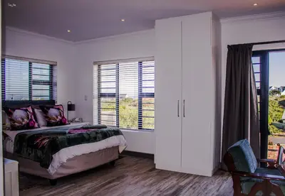 a bedroom with a bed and a large window at 41 on Siffie in Hermanus