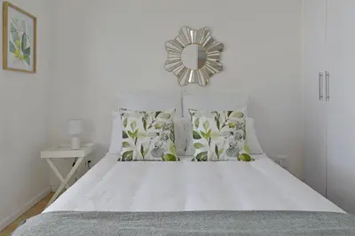 a bedroom with a bed with a mirror on the wall at 108 Waverley in Cape Town