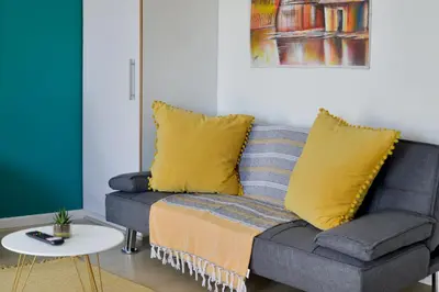 a couch with yellow pillows in a living room at 108 Waverley in Cape Town
