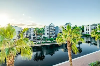 a view of a city with palm trees and buildings at Quayside Canal Eden Home in Cape Town