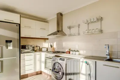a kitchen with a washer and a dishwasher at Quayside Canal Eden Home in Cape Town
