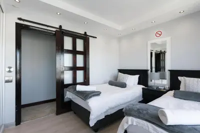 a bedroom with two beds and a mirror at Luxury Witsand 706 in Cape Town