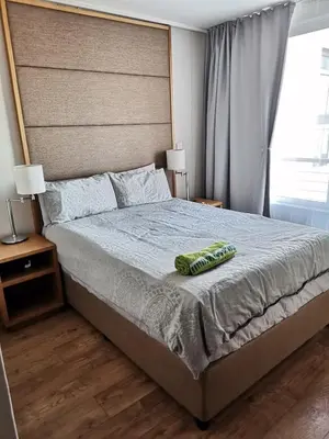 a bedroom with a large bed with two pillows on it at Lagoon Beach Apartment 309 in Cape Town