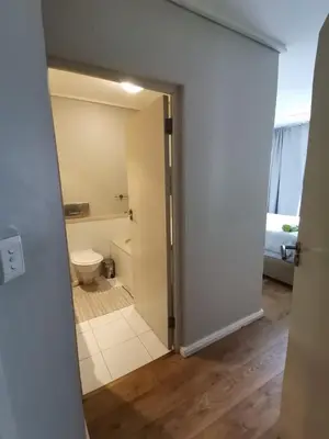 a bathroom with a door leading to a toilet at Lagoon Beach Apartment 309 in Cape Town