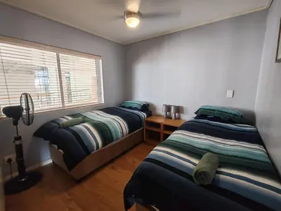 a bedroom with two beds and a window in it at Lagoon Beach Apartment 309 in Cape Town