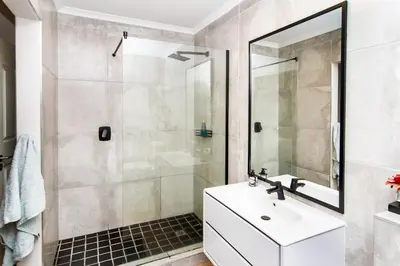 a bathroom with a white sink and a shower at Vygeboom Villa/ Durbanville in Cape Town